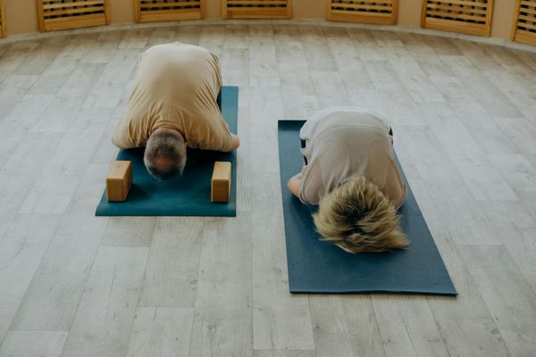 Group of people practicing yoga in a bright studio.